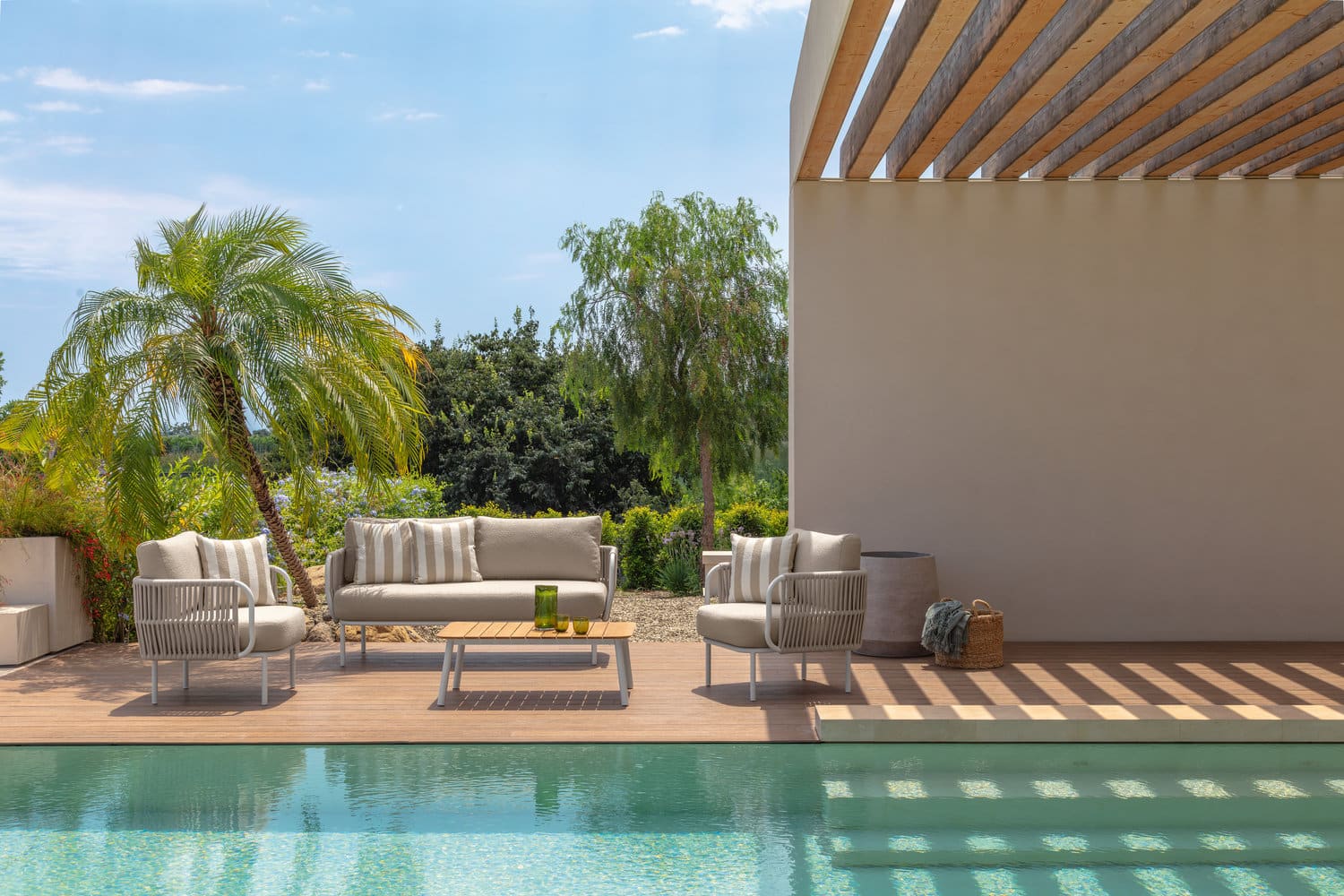 Salon de jardin design beige au bord d'une piscine